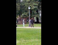 Man checkered suit video shoot at park