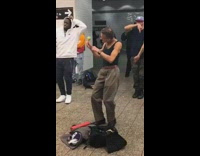 Rapper freestyle raps on microphone speakers in subway station while old man dances and shakes maracas