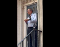 Man standing stairs feed pigeon on arms