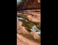 Girl slides down rocks in creek water