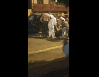 Group of men carry body into bag 