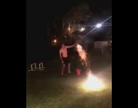 Shirtless guy in a backyard sets off fireworks 