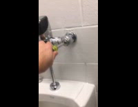 Man loosening up screws on public urinals
