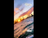 Guys ride jet ski sunset city skyline 