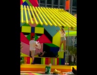 Lady in white poses with colorful stage props 