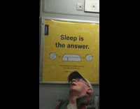 Man falls asleep in front of Sleep is the Answer sign on subway