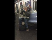 Guy covers ears while people sing subway 