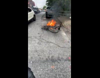 Cyclist pass by burning bike on street