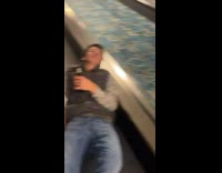 Guy on escalator laying down with beer in hand