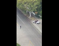 White convertible in front of beverly hills sign