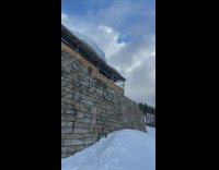 Skier jumps from roof onto slope but fails landing