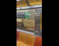 2 guys at a subway station carry a long couch together 