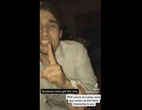 Guy in dress shirt singing poorly and dancing to a song at party