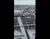 Person on roof waves flag 