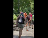 People watch two guys fight at the park