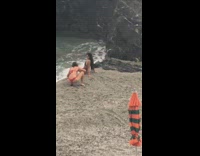 Girl gets hit by wave orange umbrella  