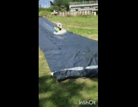 guy and girl going sliding down slip and slide and falling down