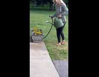 Collab BitchMP - Woman sprays hose into watering can over flowers