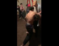 two shirtless guys wrestle in frat house