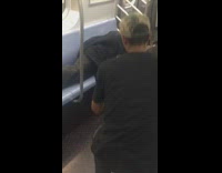 Guy asleep under black blanket subway wet floor pee