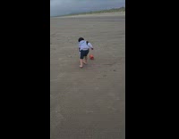 Kid struggle catch bucket blown by wind
