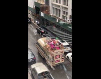 People in party outfits sitting atop party bus