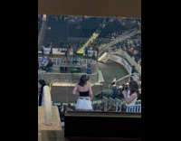 Collab IITW - Woman black tube top white skirt poses at concert