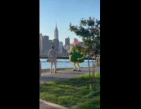 Guy films watermelon mascot dance at park