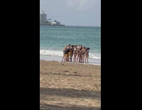 Women in bikini in line and holds each others butt