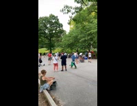 Music plays at a park while people stand 