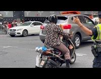 Cat wearing bling rides motorcycle with owner