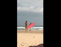 Girl poses with pink surfboard