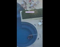 Woman in pool spin around railings selfie