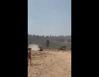 Guys sit on van roof as it drives through desert