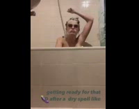 Girl dances in shower sunglasses champagne bottle 
