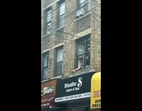 Girl shave her legs outside the window of the building 