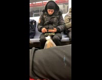 Guy on subway train rolling a joint with a marijuana tray