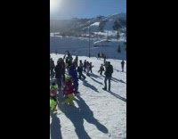 Woman in pink outfit poses at the snowy mountain