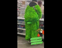 Man in the Grinch Costume Pays on Counter