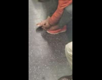 Guy takes off red shoes and picks crusty toes on subway train