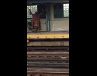 Person in tribal traditional clothing plays the flute at train station