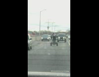 Guy on 4 wheeler does wheelies on freeway