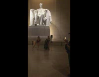 Two girls dance Lincoln statue security guard