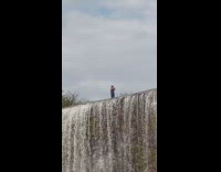 Man in black tank top selfie on top of the waterfalls