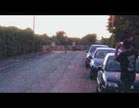 Blue shorts guy skateboards backwards down road