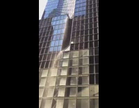 Broken pipe leaks out water on the side of tall business building