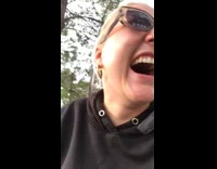 Black sweater girl lifts up sunglasses laughs 