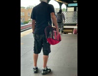 Guy has white birds inside red bag 