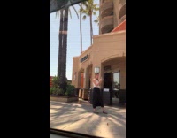 Woman with drinks poses outside grocery store