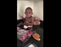 baby eats bread on kitchen counter top